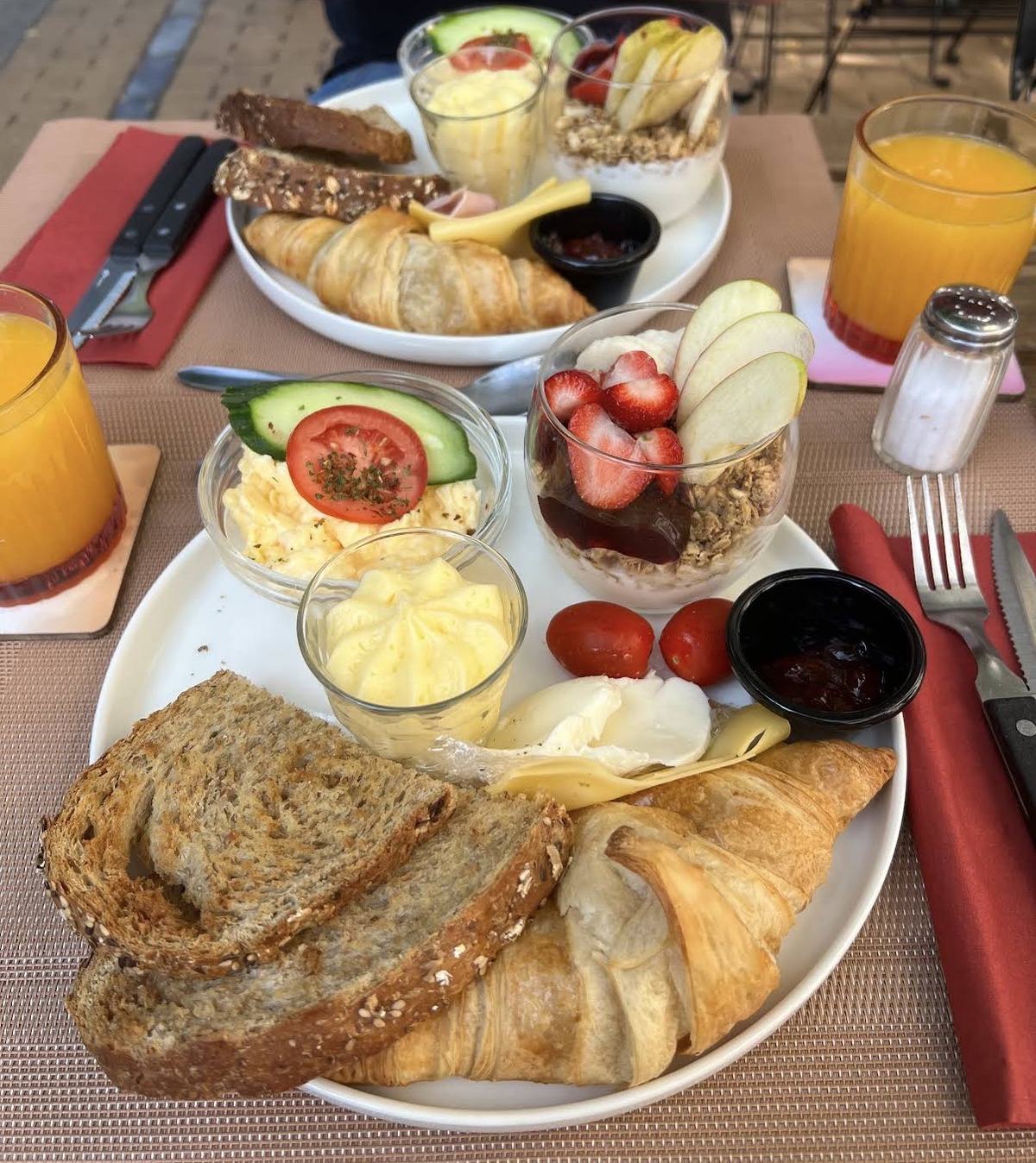 Ontbijtplank met croissant, vers brood, yoghurt en fruit